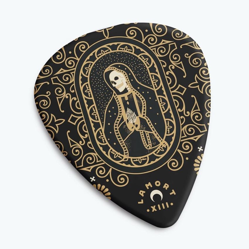Guitar pick mockup featuring a black pick with intricate gold tattoo-style artwork of a skeleton figure and ornate patterns.