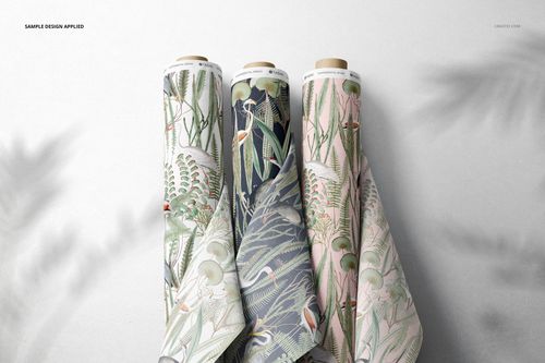 Fabric rolls mockup showing detailed plant motifs in various colors, arranged vertically on a smooth surface.