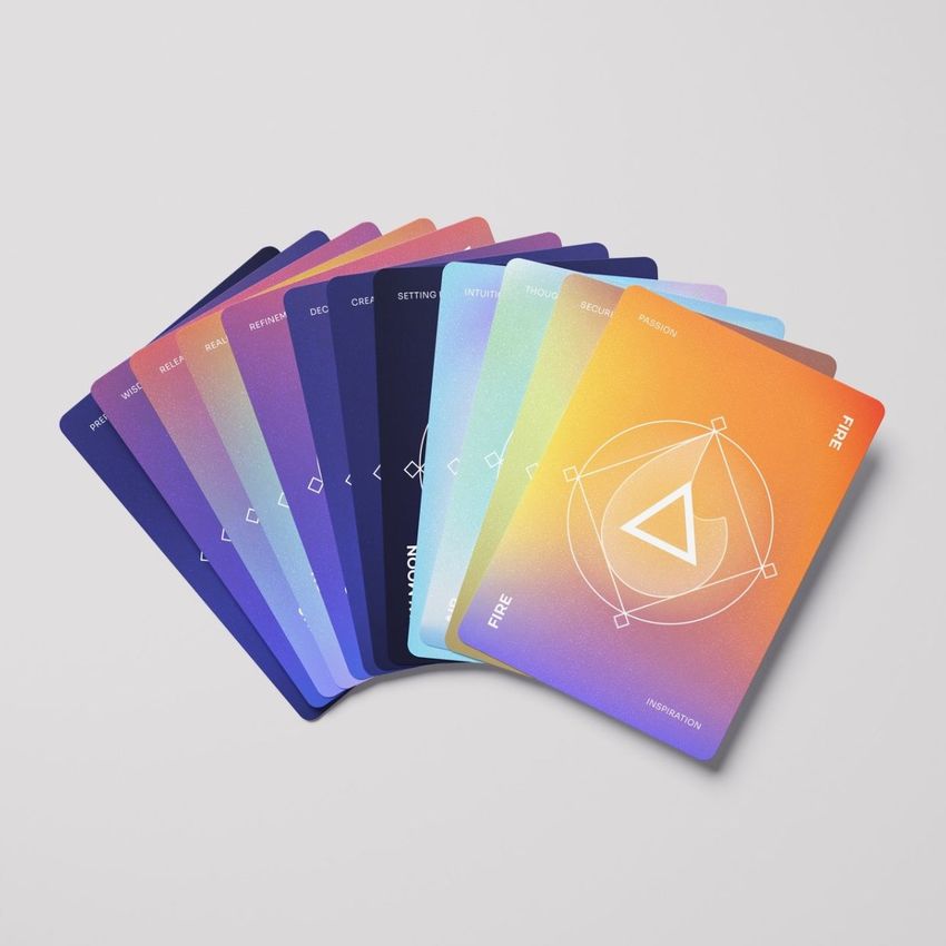 Playing cards mockup featuring a fanned arrangement of colorful cards with geometric designs and gradient backgrounds on a light surface.