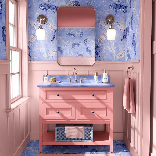 Bathroom mockup featuring a pink vanity with blue countertop, patterned wallpaper with tigers, and two wall sconces.