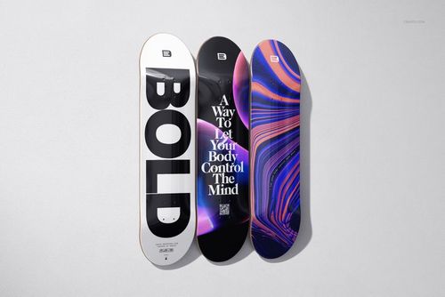 PSD mockup of three skateboard decks arranged side by side, showcasing varied text and abstract artwork on their surfaces.