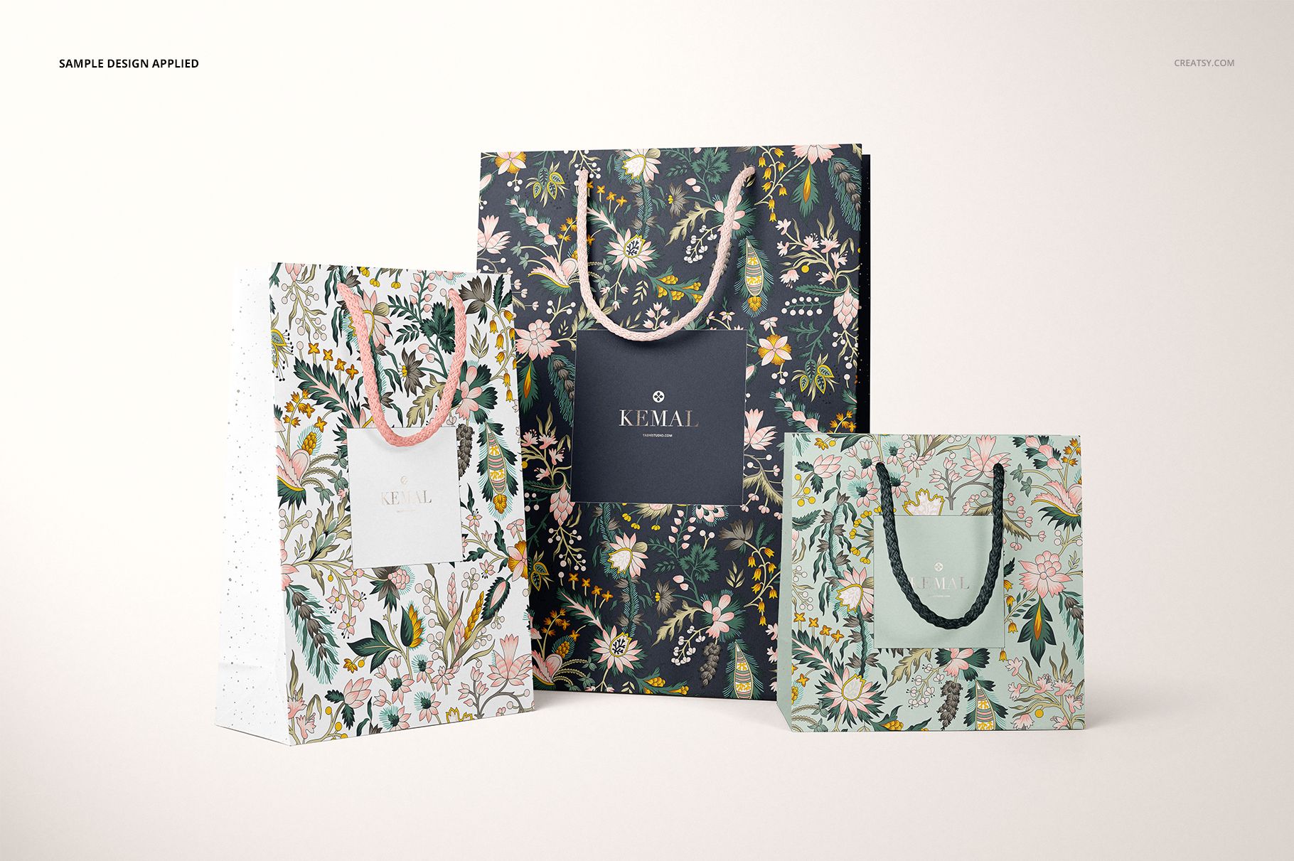 PSD mockup featuring three decorative paper bags with botanical designs and twisted handles, arranged side by side.