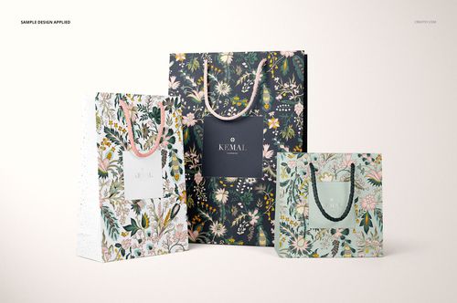 PSD mockup featuring three decorative paper bags with botanical designs and twisted handles, arranged side by side.