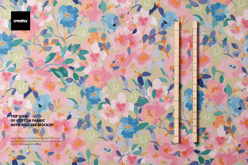 PSD mockup showing a top-down perspective of cotton fabric covered in pastel floral prints, with rulers on the surface.
