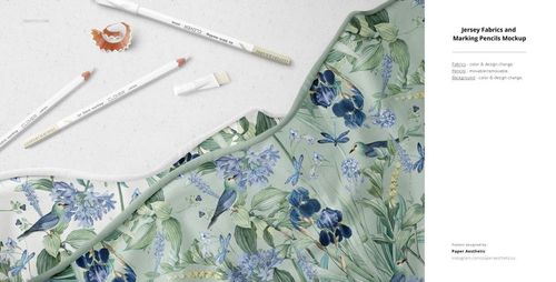 Jersey fabric mockup with a botanical pattern featuring blue flowers and birds, shown alongside white pencils on a light surface.