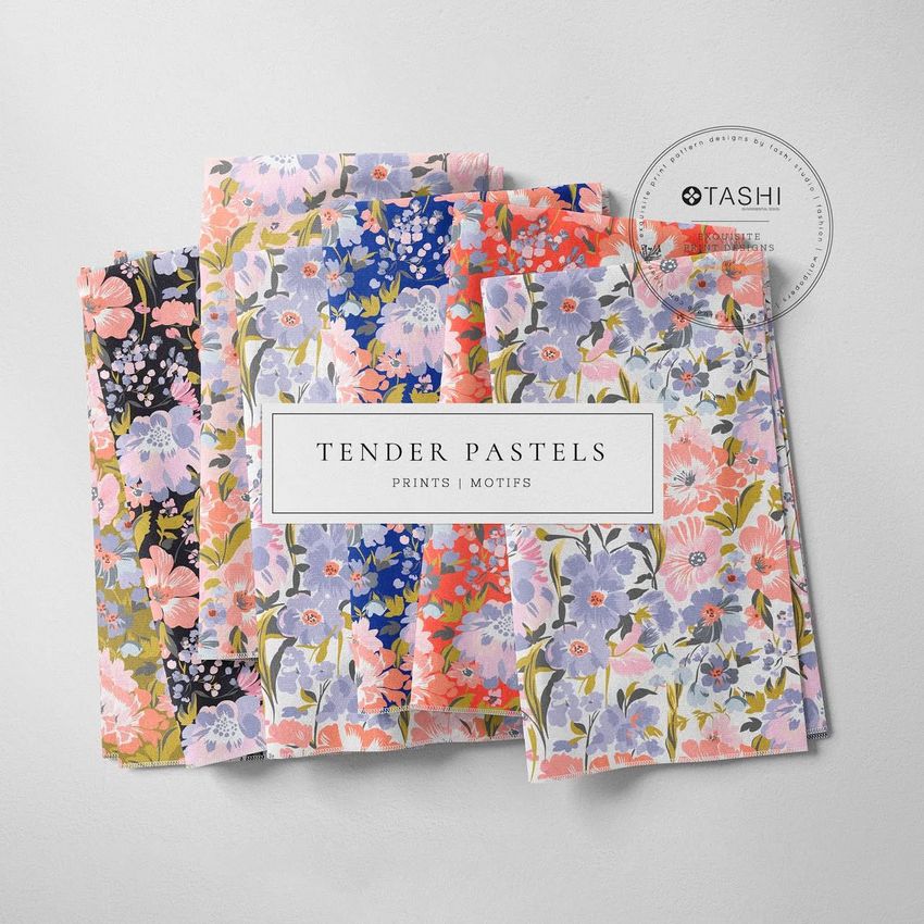 Folded fabrics mockup featuring four pieces of fabric with pastel floral patterns, arranged on a light surface with a round label.