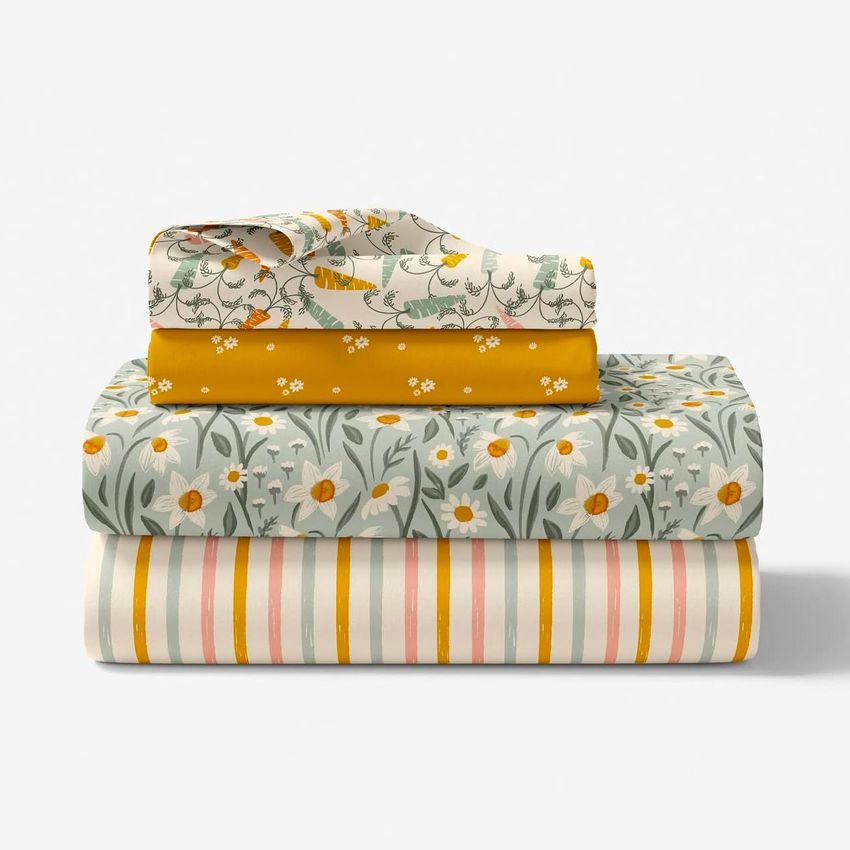 Folded bedding set mockup featuring stacked sheets with floral and striped patterns in yellow, green, and pink tones.