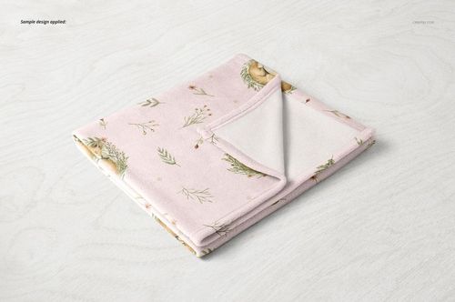 Soft fleece baby blanket mockup featuring a gentle pink color and delicate nature-themed print, displayed folded on a table.