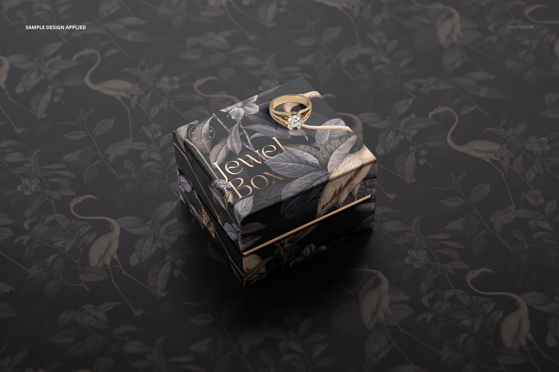 PSD mockup of a square jewelry box featuring a botanical design and gold trim, displayed on a matching surface.