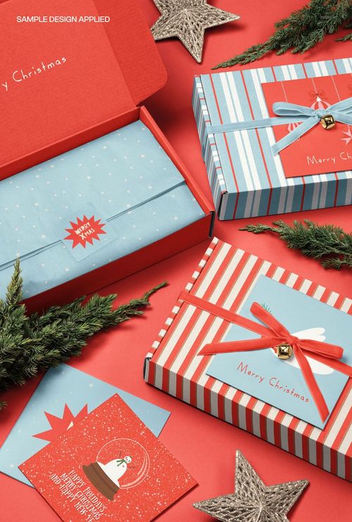 Christmas gift mailing boxes with cards and velvet ribbons arranged on a red surface, top view mockup scene.