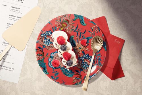 Ceramic plate mockup featuring a vibrant red floral design, dessert topped with berries, gold cutlery, and a menu.