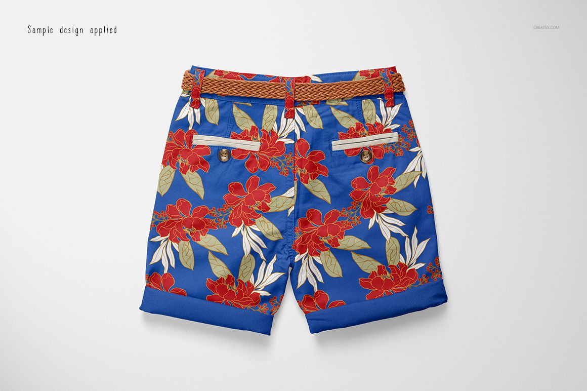 Kids shorts mockup with a vibrant blue base and large red floral pattern, shown from the back on a plain surface.