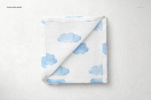 Baby muslin square nappy mockup featuring soft white material with blue clouds, displayed folded on a pale background.