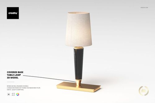 Table lamp with a rectangular gold base and black textured stand, featuring a light beige fabric lampshade, front view.