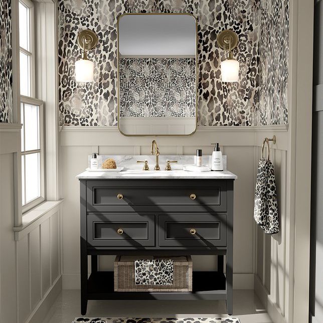 Bathroom mockup featuring a black vanity with gold hardware, animal print wallpaper, a rectangular mirror, and wall sconces.