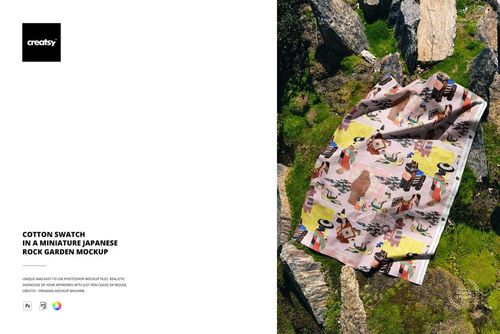 PSD mockup showing a patterned cotton fabric swatch laid out on natural rocks and greenery in a miniature Japanese garden setting.