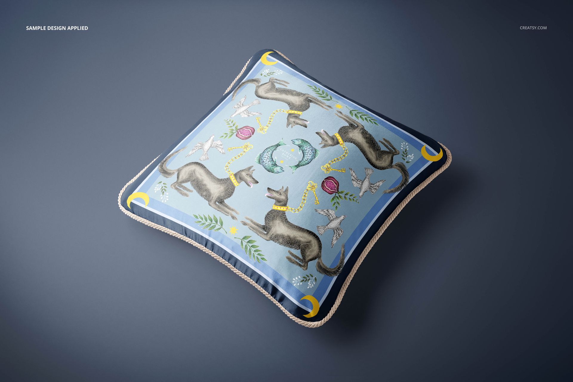 Silk cushion mockup with braided trim, decorated with illustrated dogs, birds, and plants on a blue surface.
