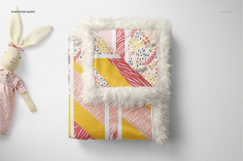 Folded sherpa baby blanket mockup with white fluffy border, featuring colorful geometric and leaf patterns, top view.