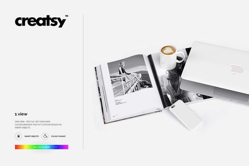 PSD mockup scene featuring a white mug, phone case, and laptop arranged beside an open book on a clean white background.