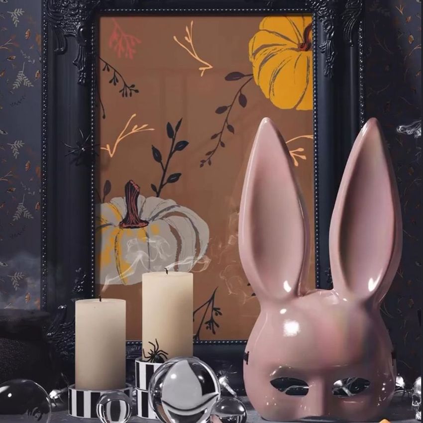 Halloween-themed ornate picture frame mockup featuring a pumpkin art print, with candles and decorative objects in the foreground.
