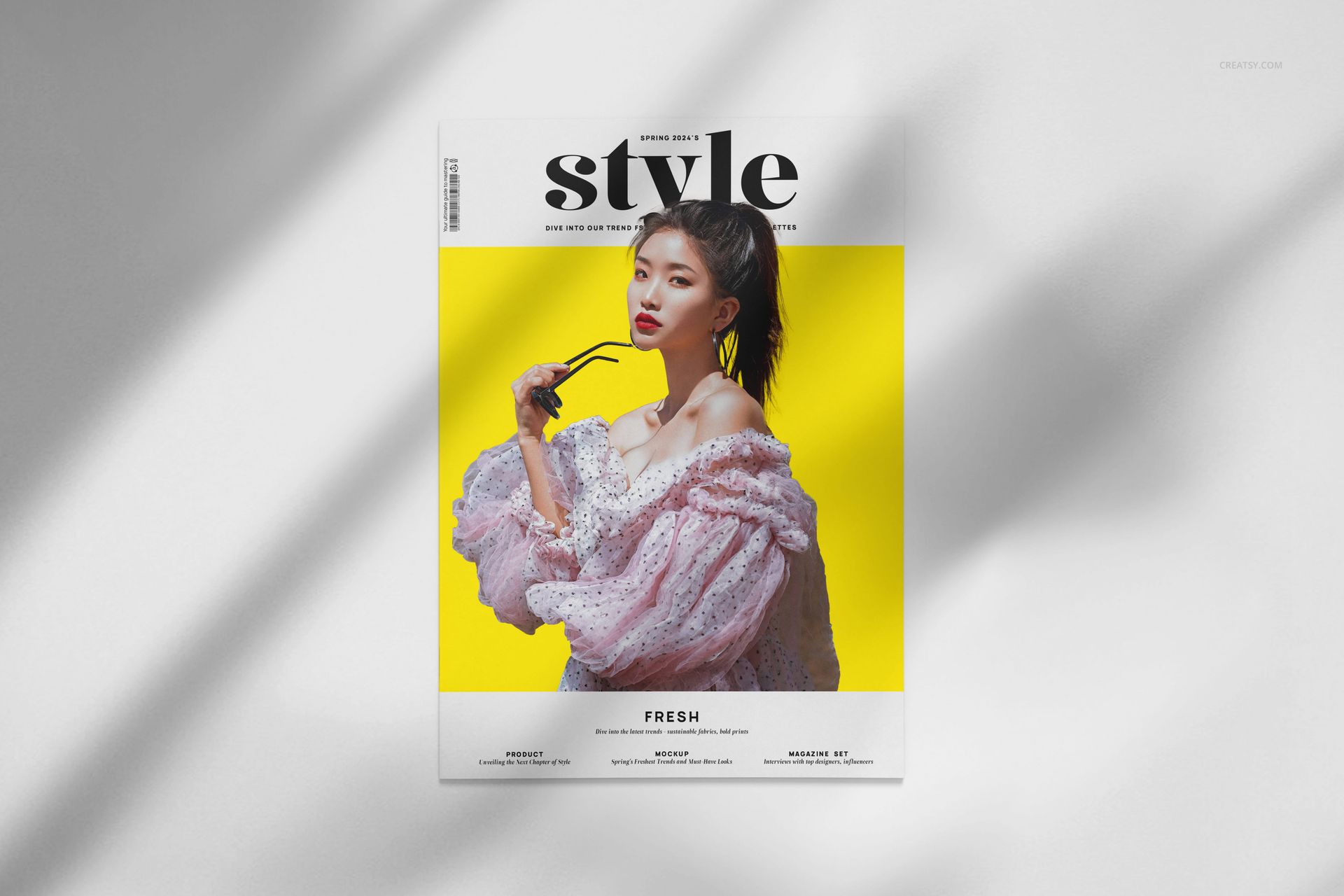A4 magazine mockup with a white cover featuring a person in a pink textured outfit against a bright yellow background.