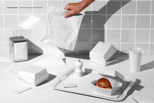 Burger packaging set mockup featuring white boxes, paper bag, and tray with burger, drink, and condiments in a tiled kitchen setting.