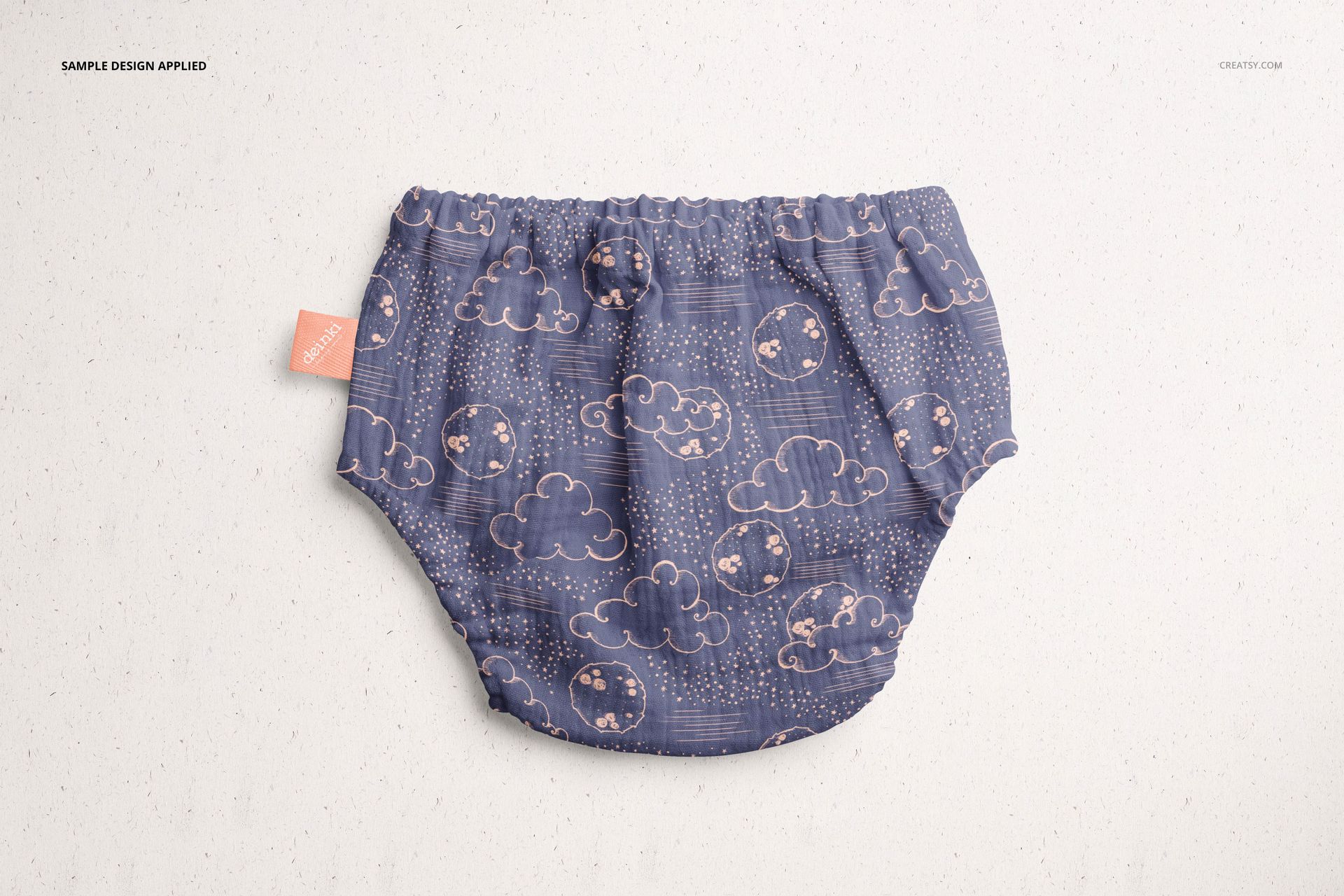 Baby muslin pants mockup featuring a blue fabric with cloud motifs, shown from above on a neutral background.