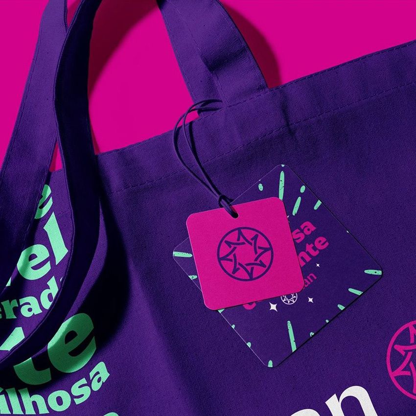 Canvas tote bag mockup featuring a close-up of the handle and attached square tag, set against a vibrant pink background.