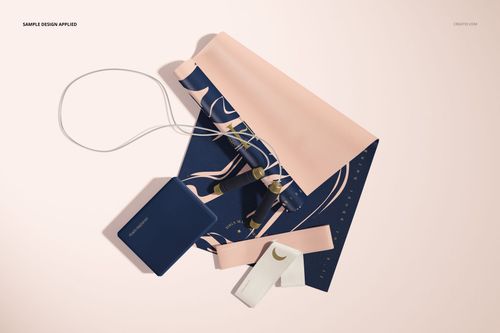 Flat lay of a yoga mat mockup featuring pastel pink and navy colors, shown with a strap, pouch, and water bottle.