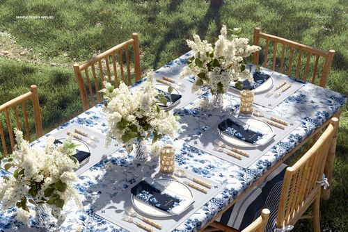 PSD mockup of a table arrangement in a grassy garden, showing tablecloth, napkins, placemats, and decorative flowers.