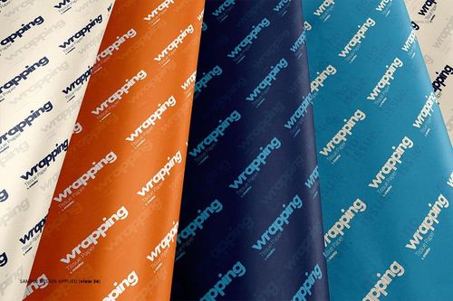 Front view of wrapping tissue paper mockup bundle featuring four colored sheets with diagonal text patterns.