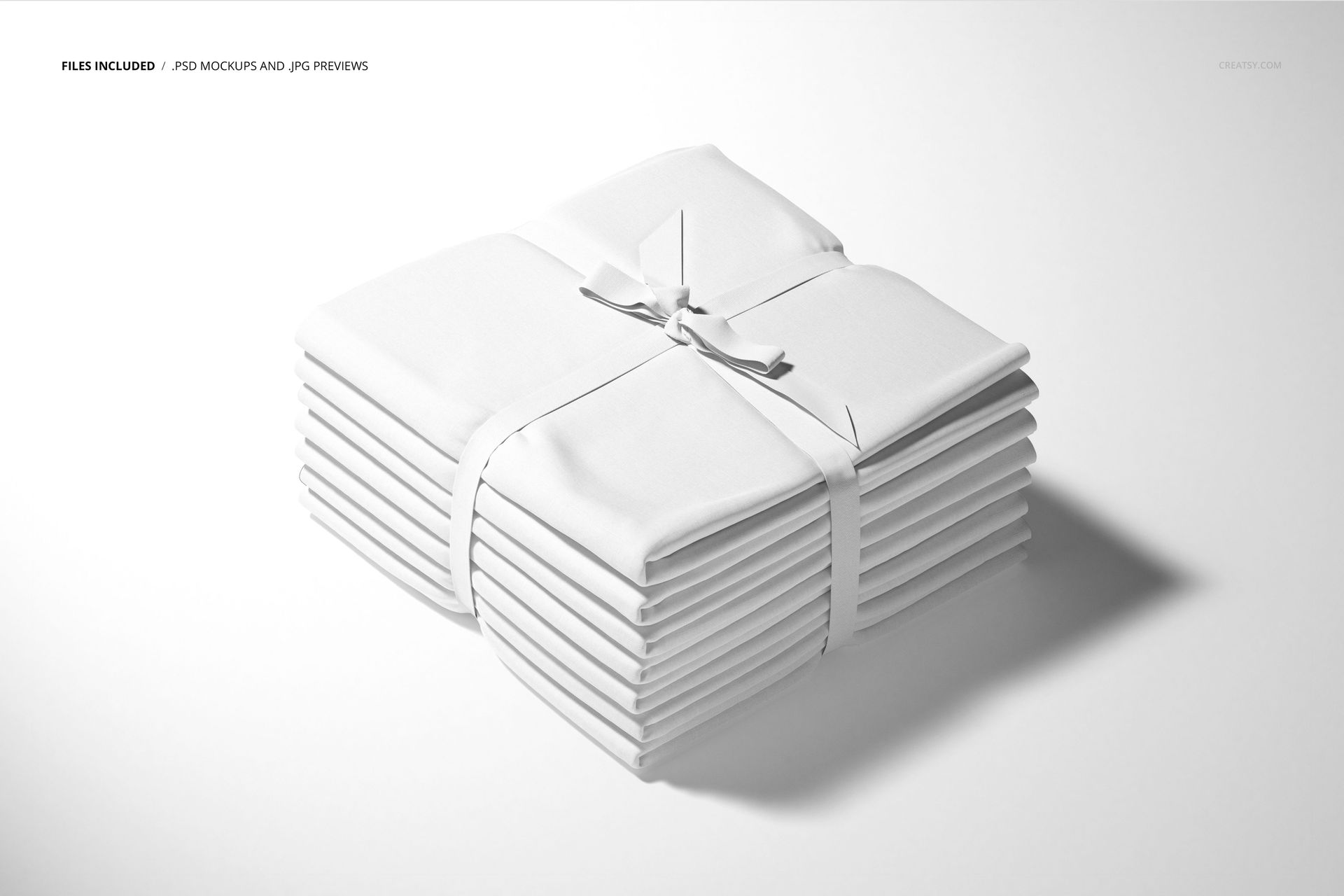 Fabric stack mockup featuring several folded white textiles arranged in a pile and tied with a white ribbon.