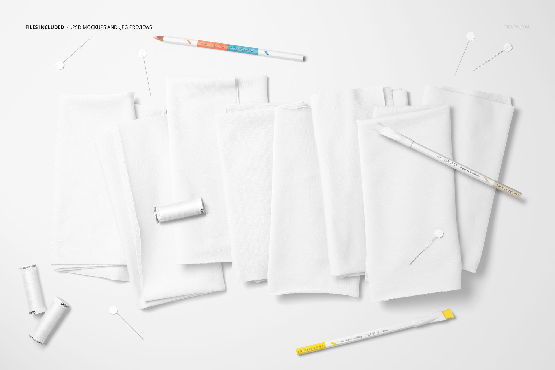Assorted white jersey fabric swatches laid out with sewing tools such as pins, pencils, and spools of thread, PSD mockup.