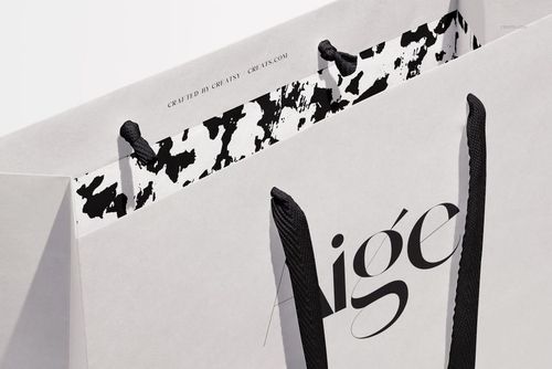 Close-up of a paper gift bag mockup with black ribbon handles and a striking monochrome interior design.
