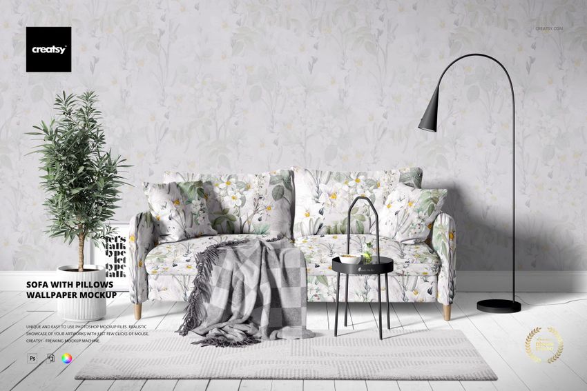 PSD mockup showing a sofa with matching pillows, floral wallpaper background, and decorative props in a living room.