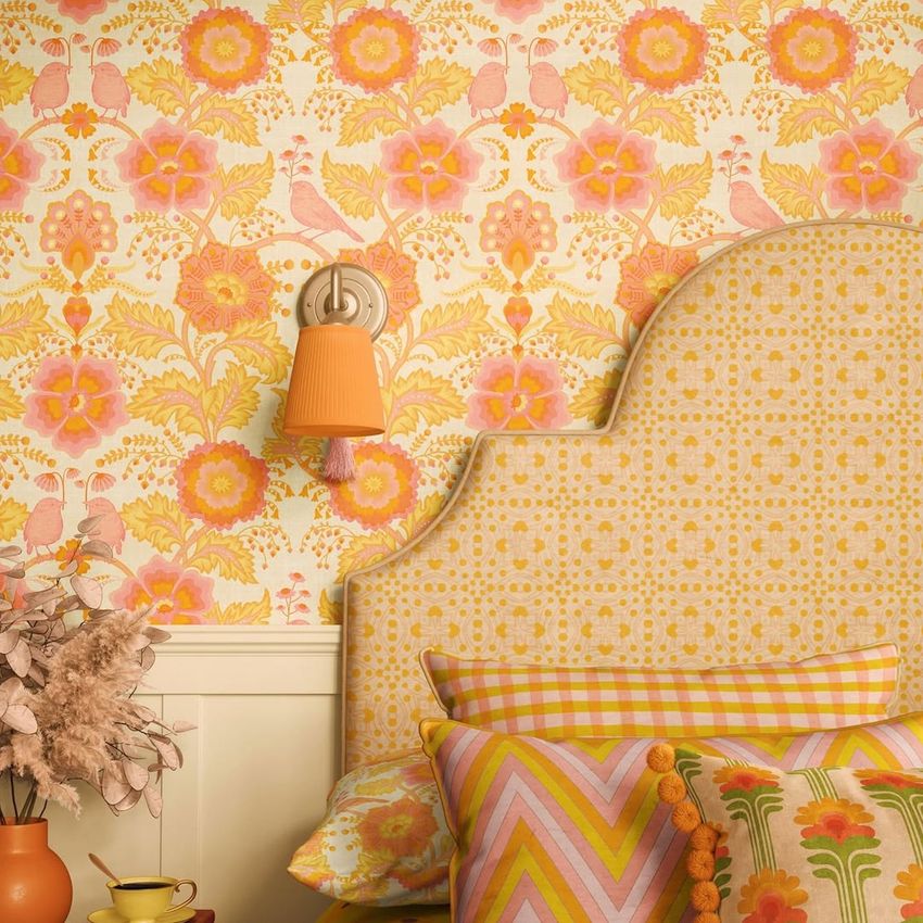 Bedroom pillows, patterned headboard, and wallpaper mockup featuring bold floral and geometric designs in pink, orange, and yellow tones.