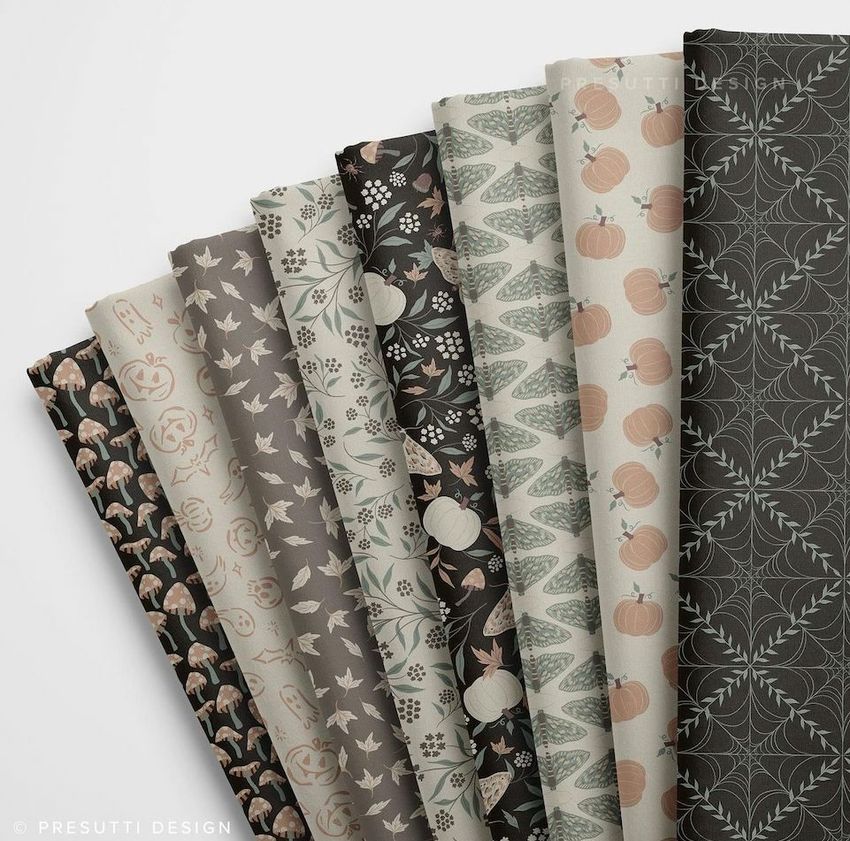 Folded fabrics mockup featuring eight fabric pieces arranged in a row, each with autumn or Halloween-themed patterns.