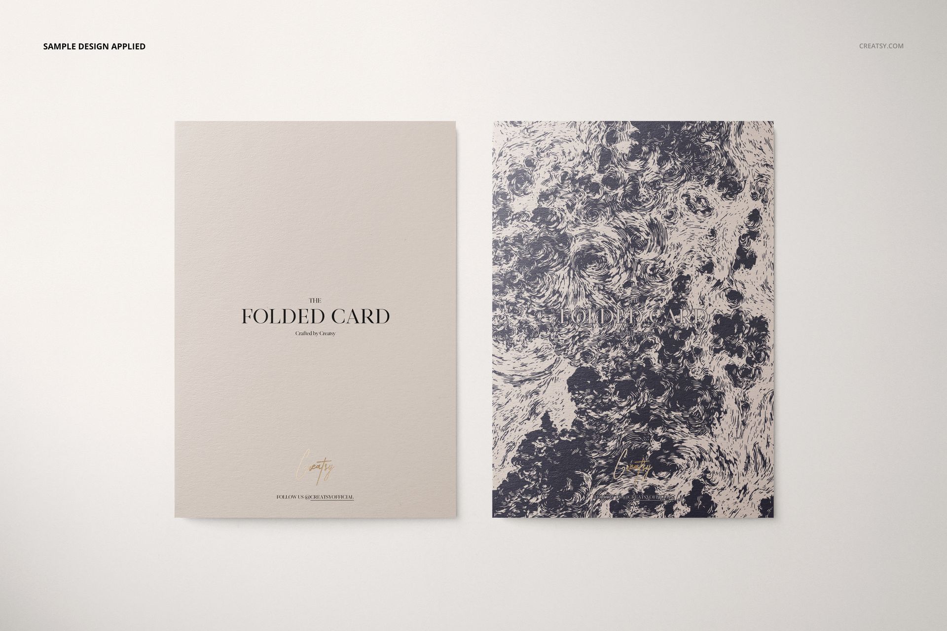 Folded card mockup set featuring two cards on a light surface, one with text and one with a marbled pattern, top view.