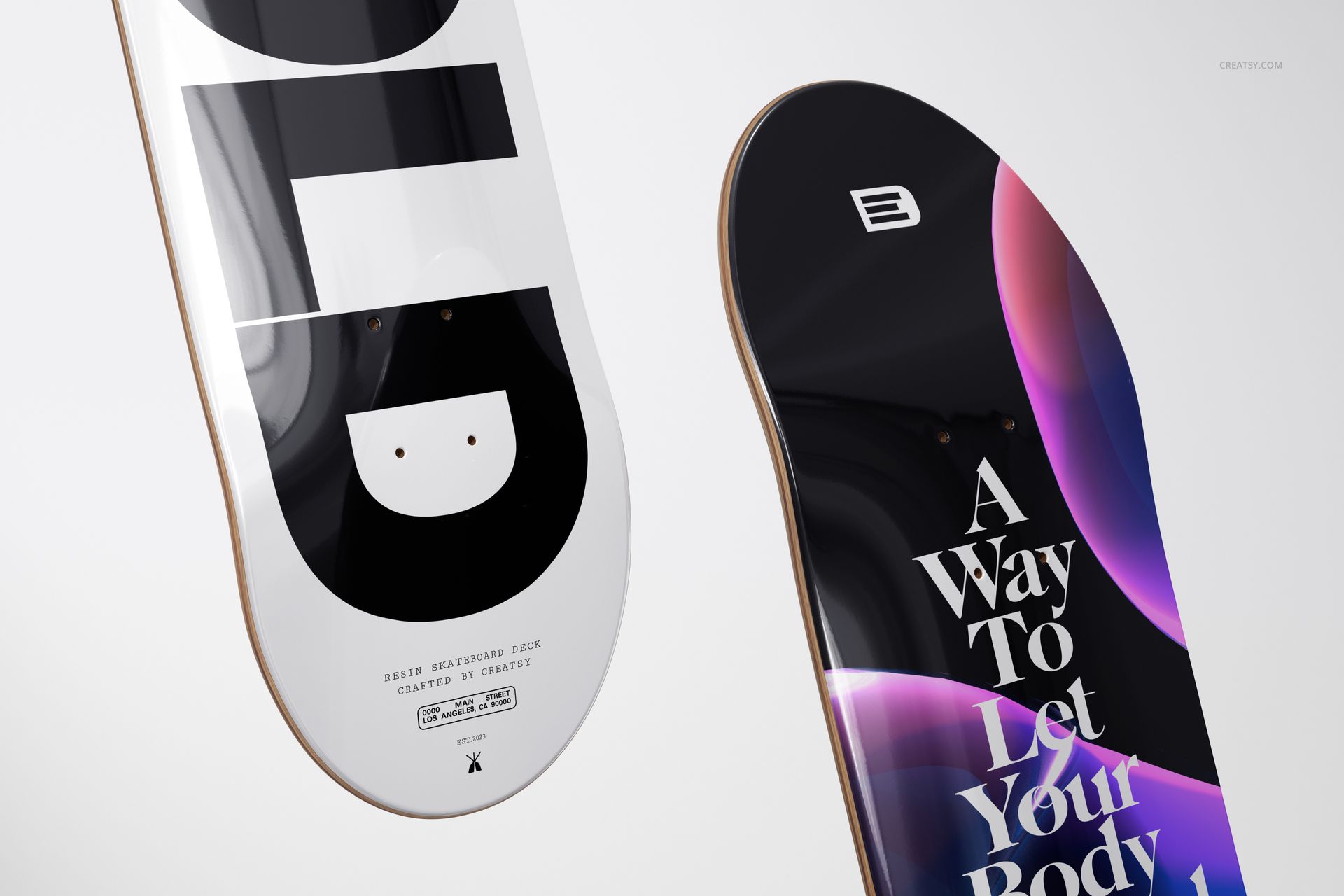 PSD mockup showing a pair of skateboard decks, one with monochrome geometric print, the other with vibrant abstract artwork.
