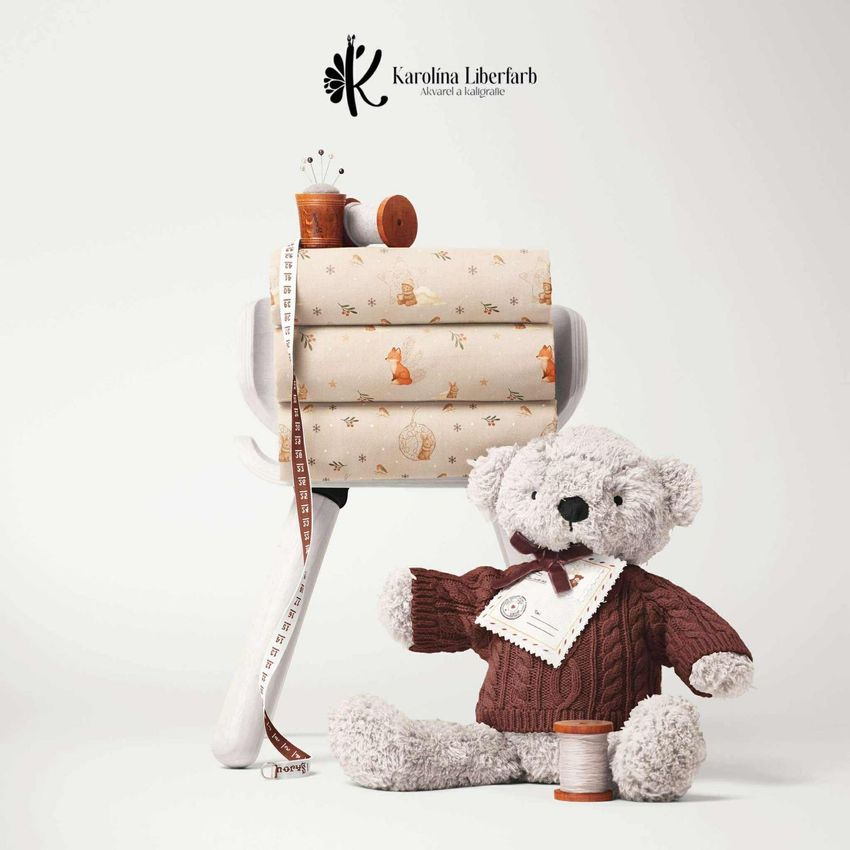 Stack of cotton fabric mockup with woodland animal patterns, displayed on a white stand next to a plush teddy bear in a knitted sweater.
