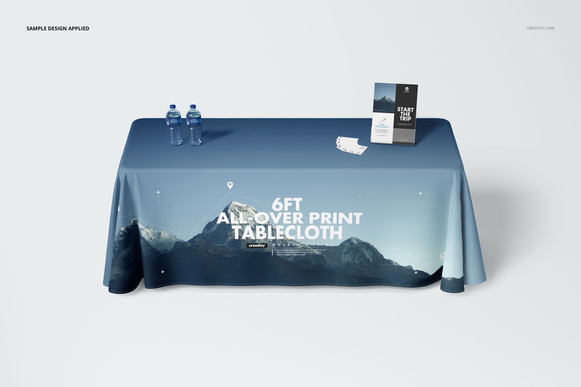 6ft tablecloth mockup featuring an all-over print of mountains, shown on a table with water bottles and printed materials.