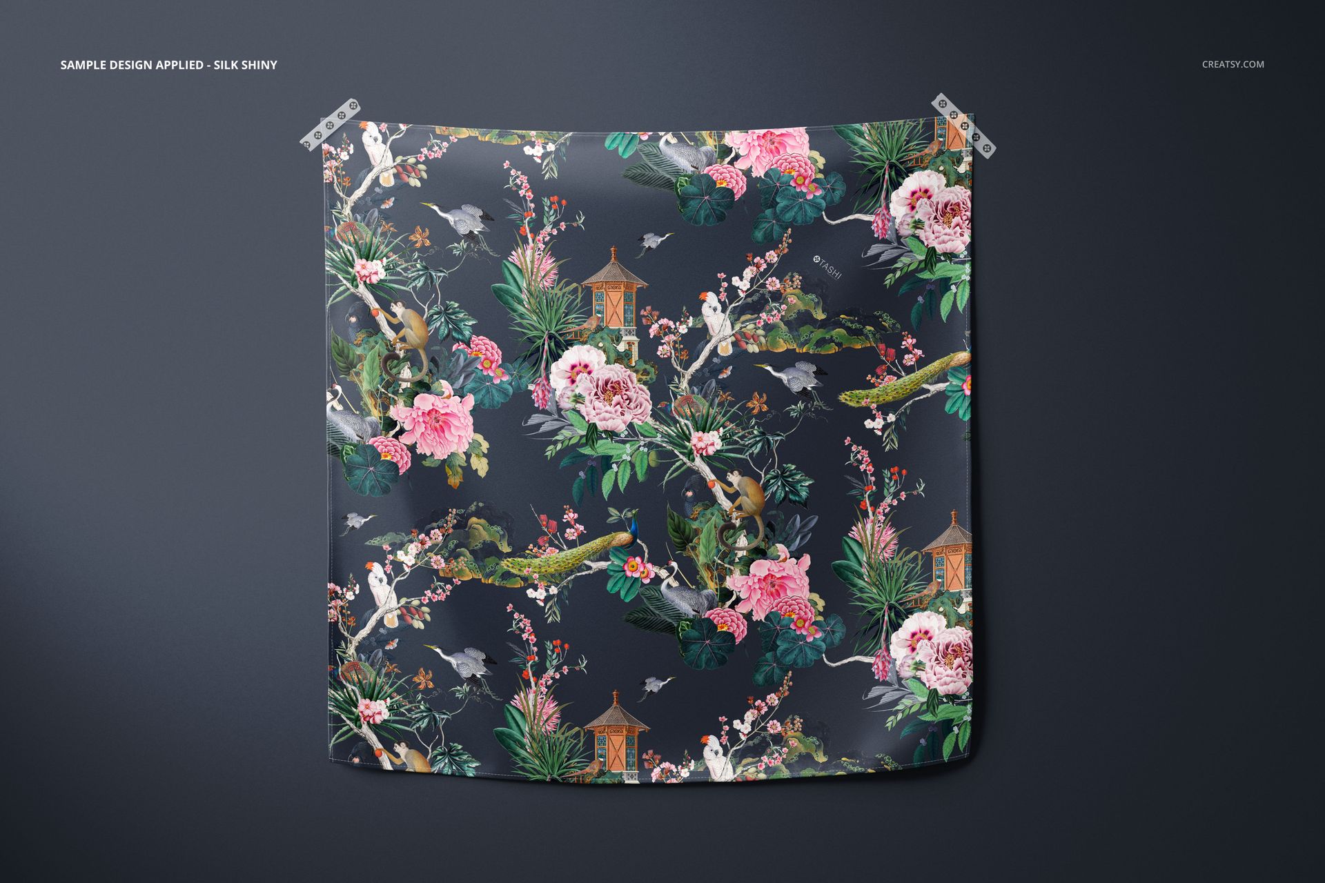 Furoshiki fabric wrap mockup featuring vibrant flowers, birds, and greenery on a dark backdrop, displayed flat.