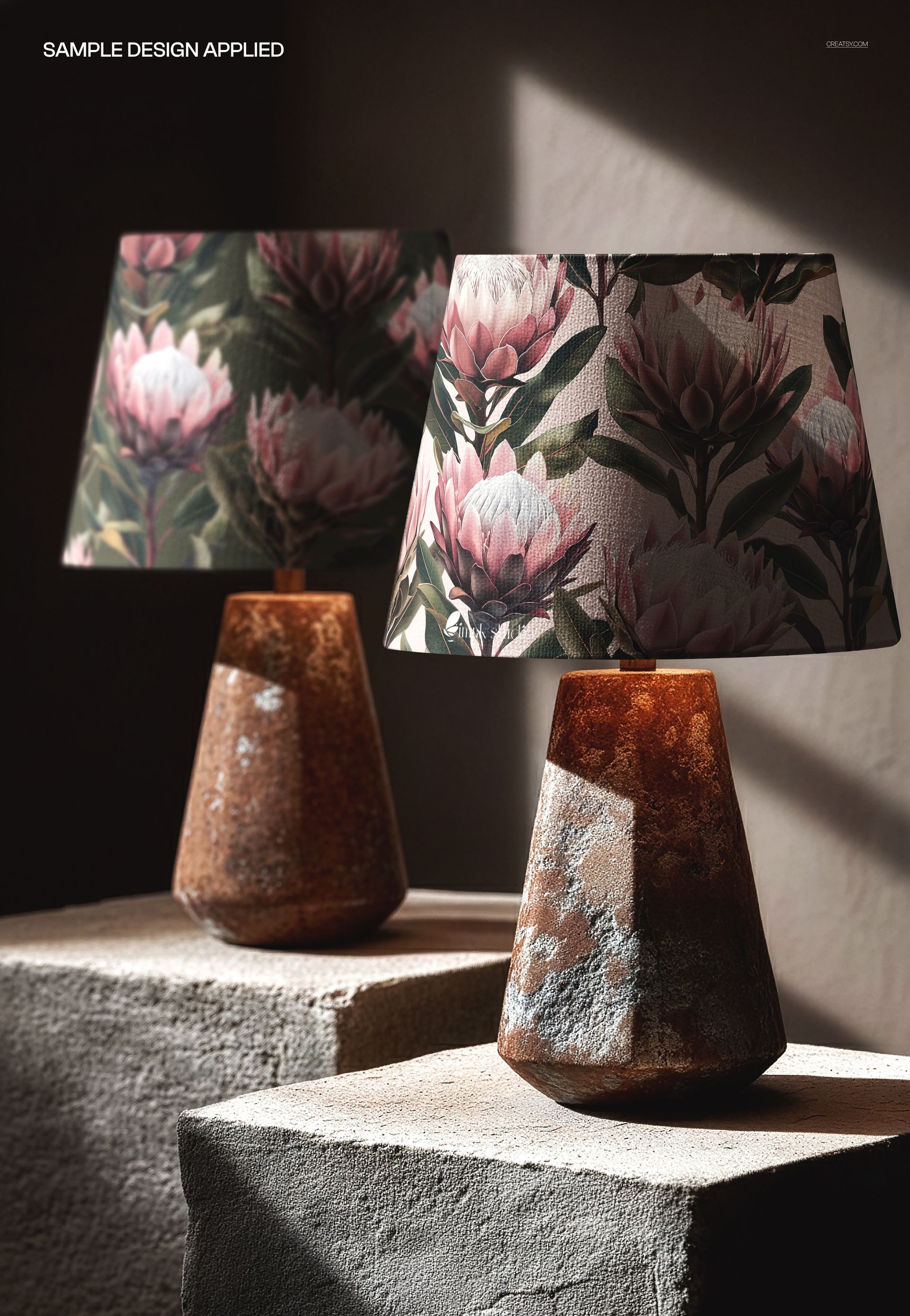 Stone base table lamps with pink and green floral shades, displayed side by side on rough concrete surfaces in a mockup scene.