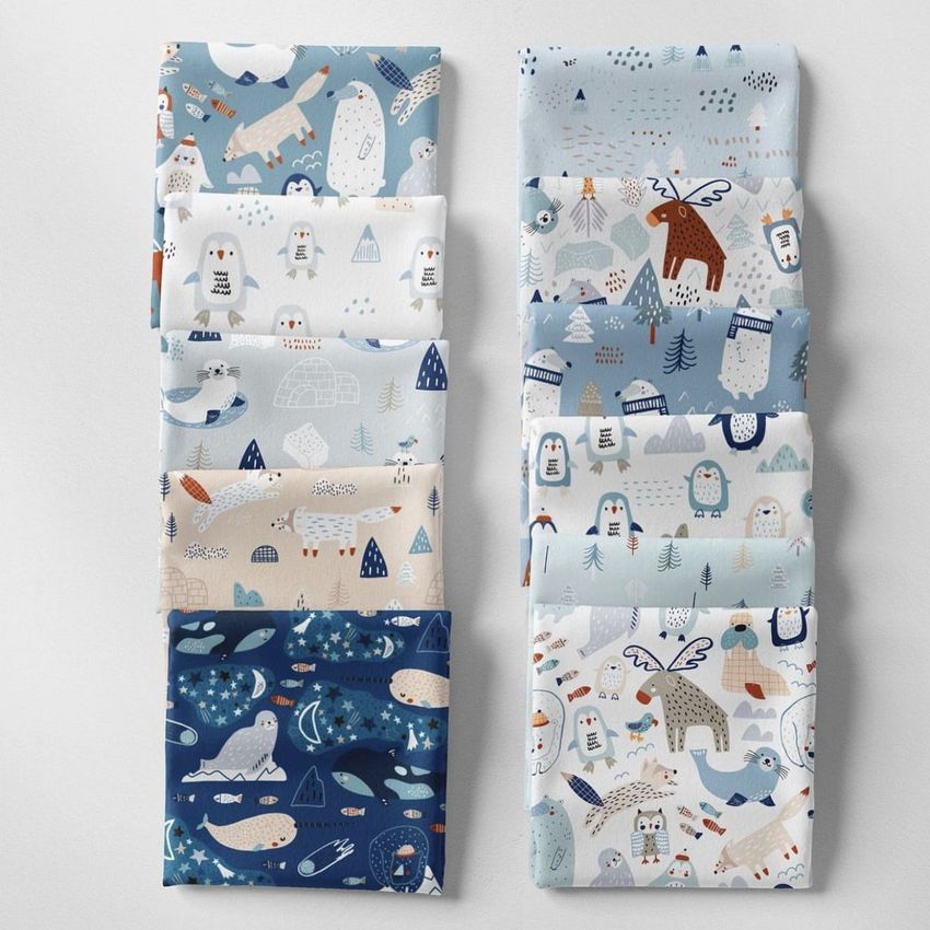 Folded fabrics mockup featuring two stacks of patterned fabric with playful animal and nature designs in soft pastel colors.
