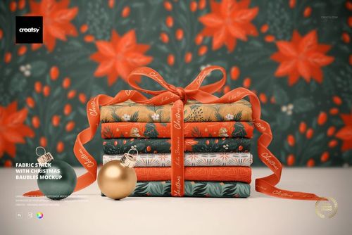 Christmas-themed PSD mockup showing stacked fabrics with holiday patterns, ribbon, and decorative baubles in a festive scene.