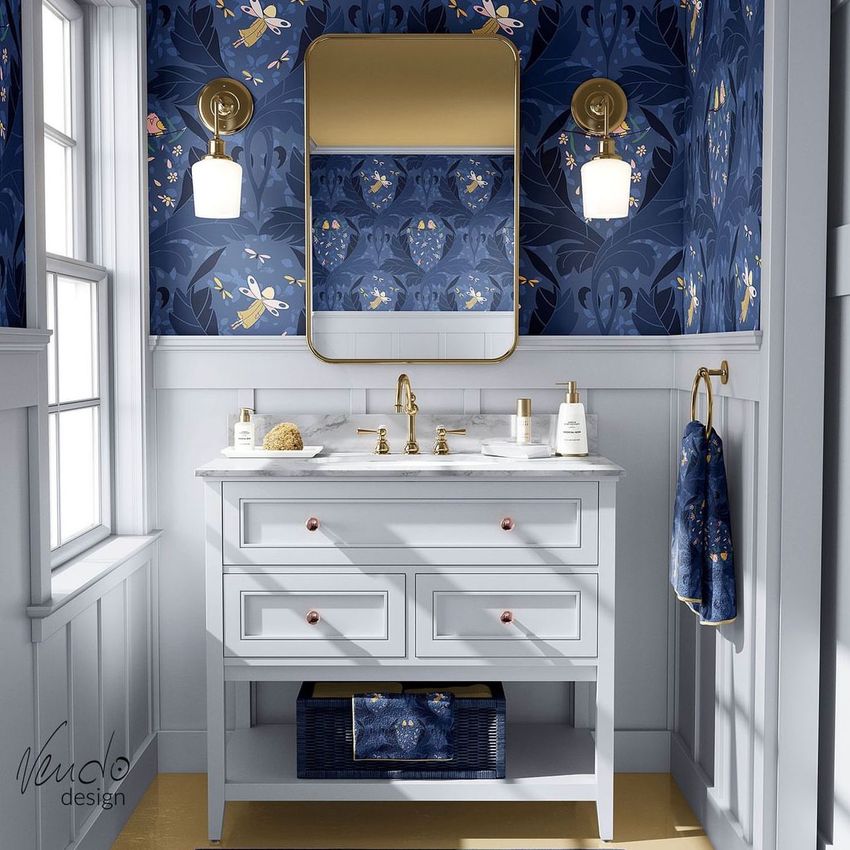 Bathroom mockup showing a white vanity with gold fixtures, a marble countertop, and blue fairy-themed wallpaper with two wall sconces.