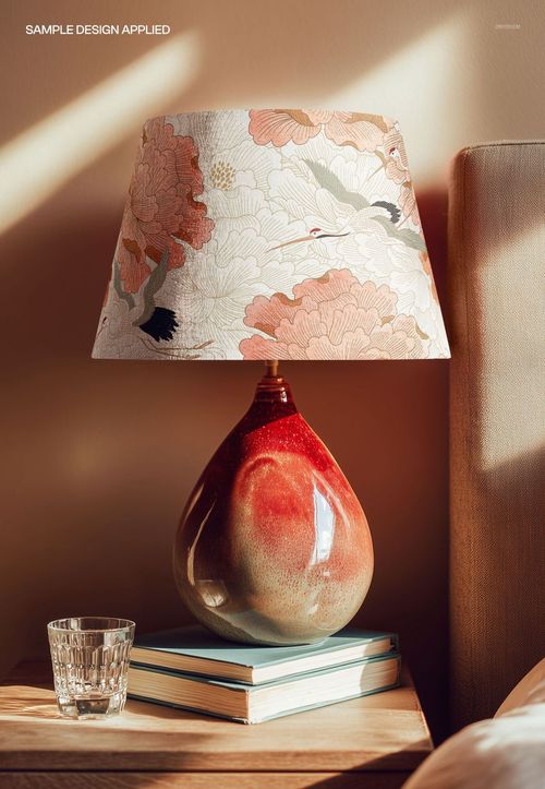 PSD mockup of a teardrop-shaped ceramic table lamp featuring a floral lampshade, set in a cozy home interior scene.