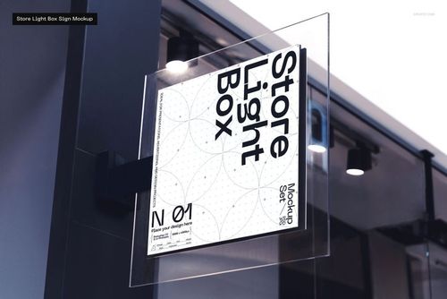 Square glass store light box sign mockup with a white geometric design, mounted on a metal bracket outside a shop.