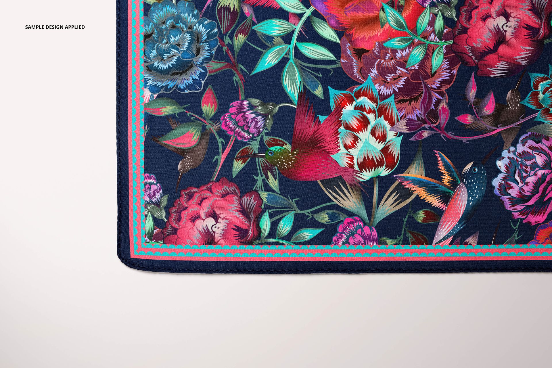 Detailed close-up of a square silk scarf mockup featuring colorful flowers and birds on navy fabric.