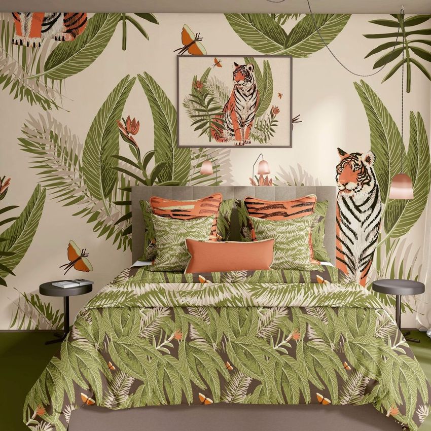 Bedroom scene bedding mockup featuring green botanical patterns with tiger illustrations on the duvet, pillows, and wallpaper.